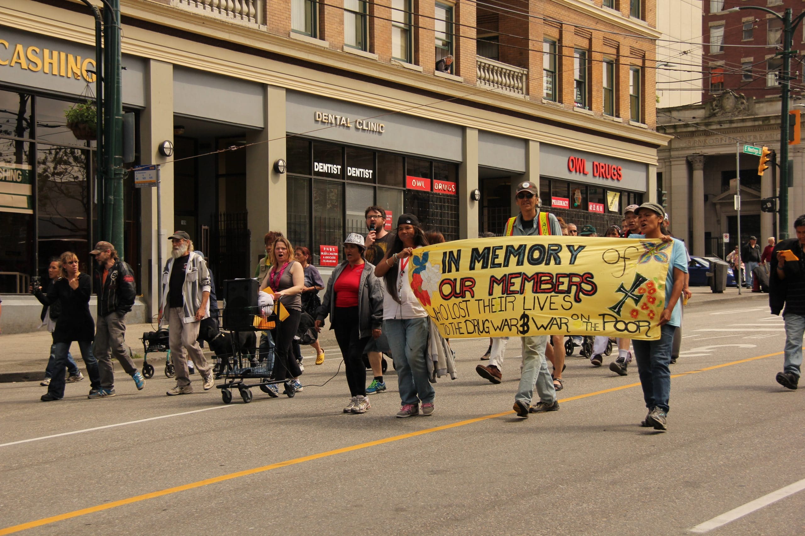 Members of the Downtown Eastside community marching up Hastings Street in Vancouver with banners